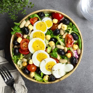 Insalatona vegetariana con uova, olive nere, fagioli canellini al vapore e nocciole pelate